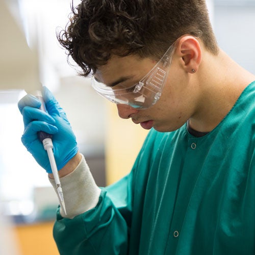 Male student using a pipette in the lab